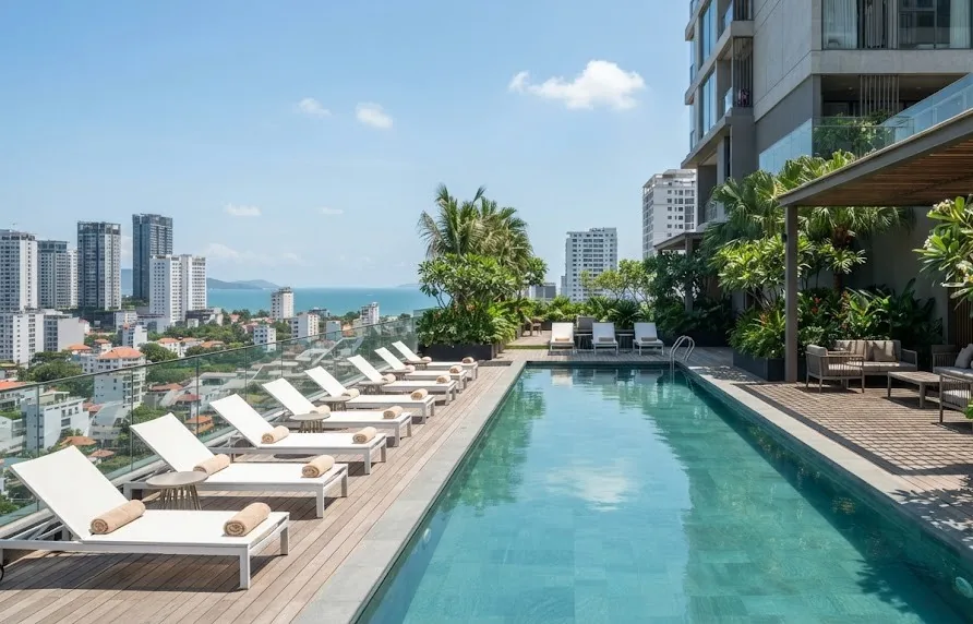 Rooftop lap pool with sun loungers at a serviced apartment building overlooking the sea