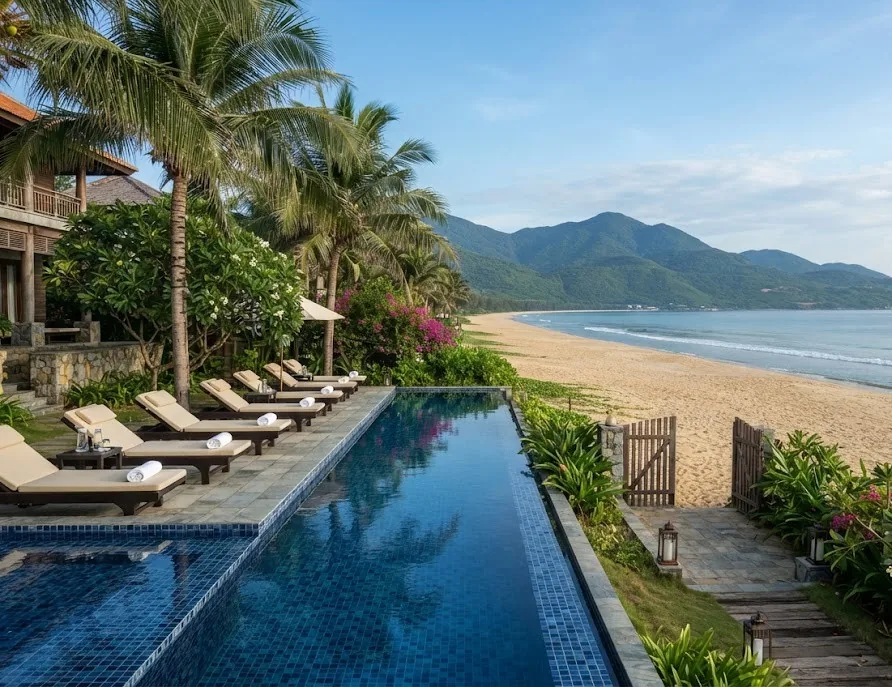 Beachfront resort infinity pool with loungers and a gate opening onto the sand