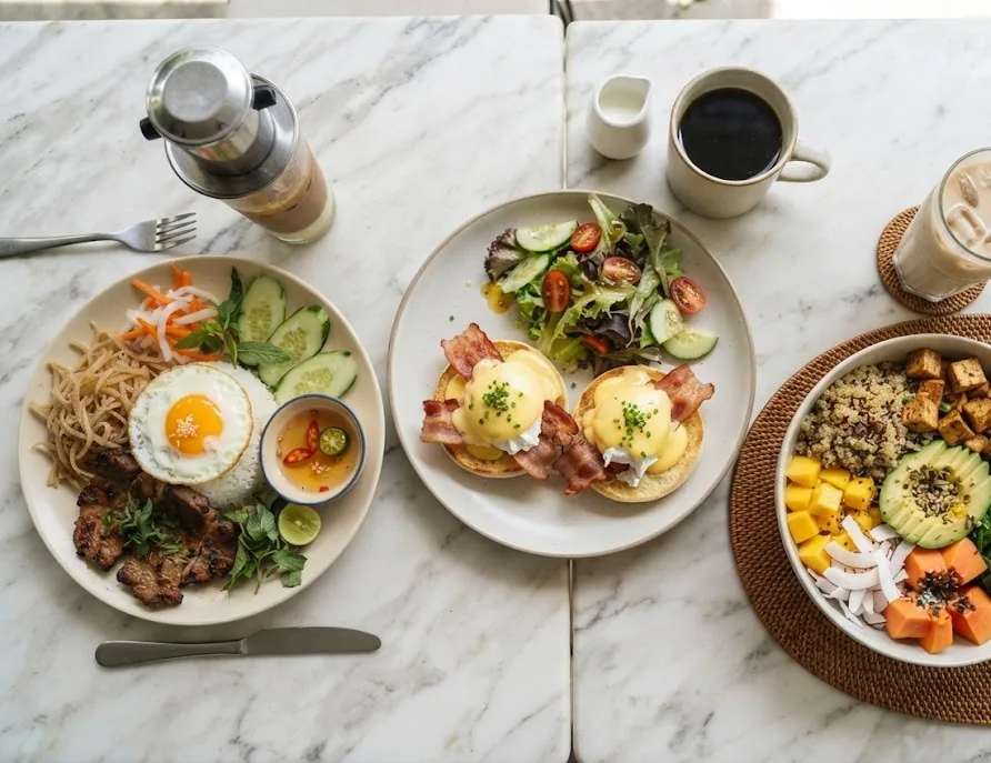 Three brunch plates: broken rice with pork, eggs benedict and a vegan tofu bowl