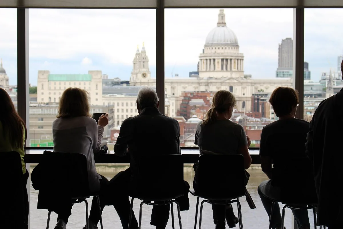Customers at a cafe window counter looking out over the city