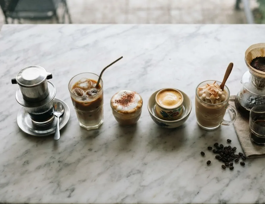 Row of Vietnamese coffee styles: phin drip, iced milk, salt, egg and coconut coffee