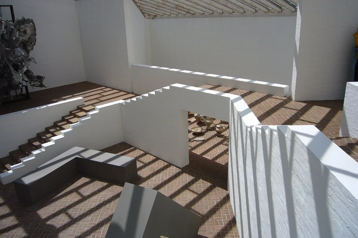 A minimalist white staircase and gallery landing lit from above
