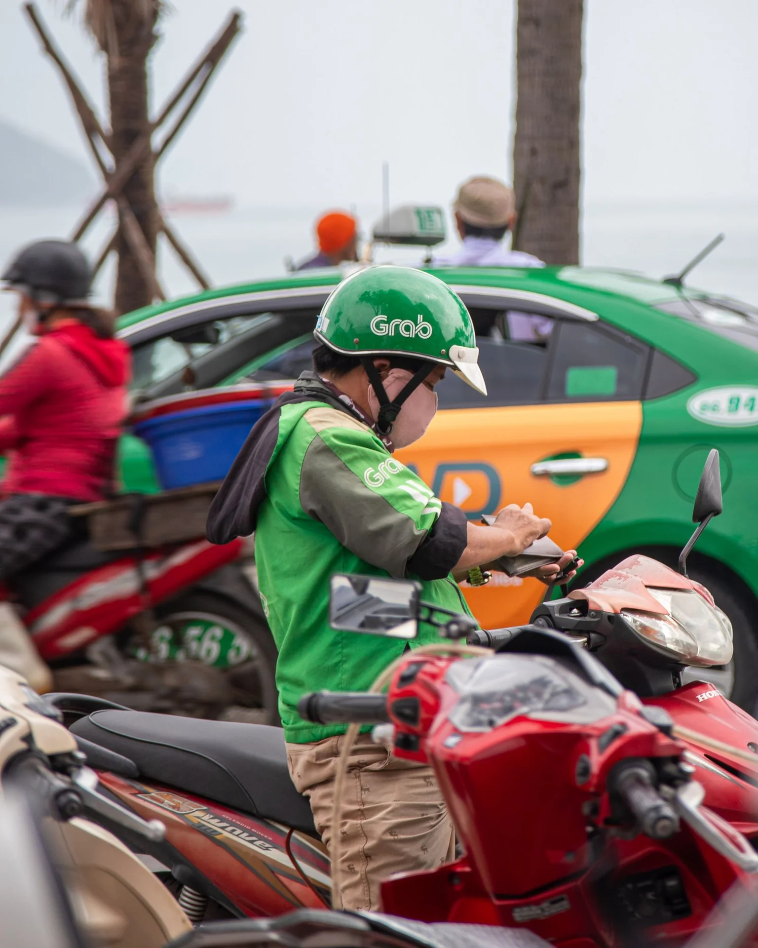 Grab motorbike driver in a green jacket and helmet in Da Nang