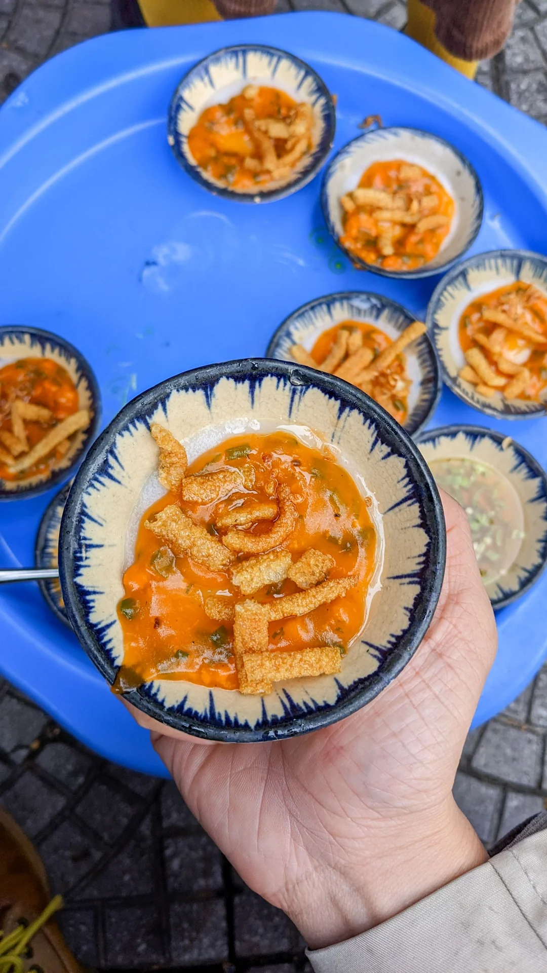 Hand holding a bowl of Vietnamese steamed rice cakes in Da Nang