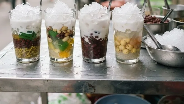 Glasses of layered che with beans, jelly, coconut milk and crushed ice