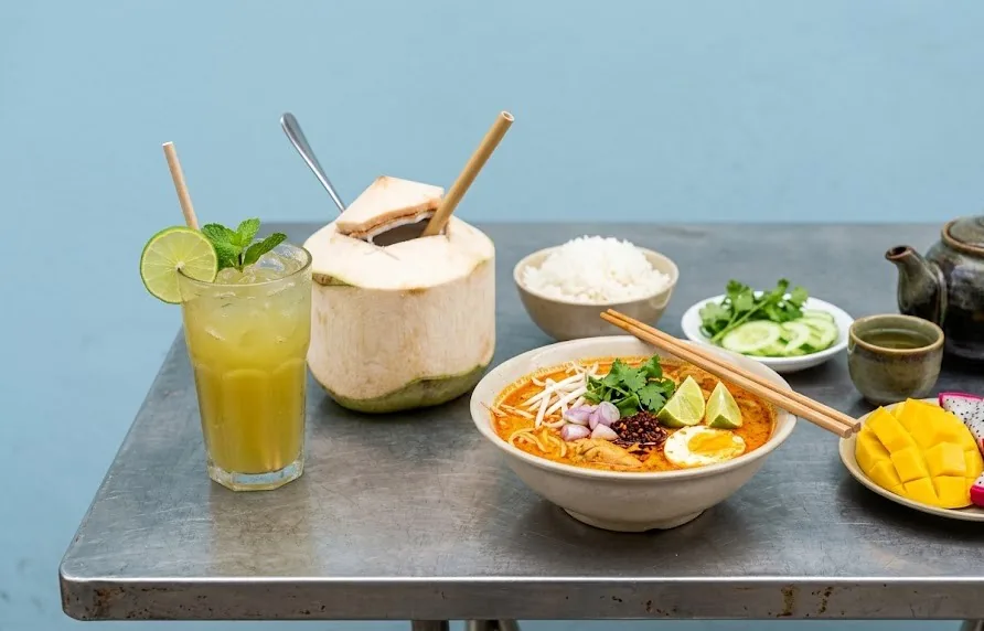 Spicy curry noodles with sugarcane juice, fresh coconut, rice, cucumber, tea and fruit